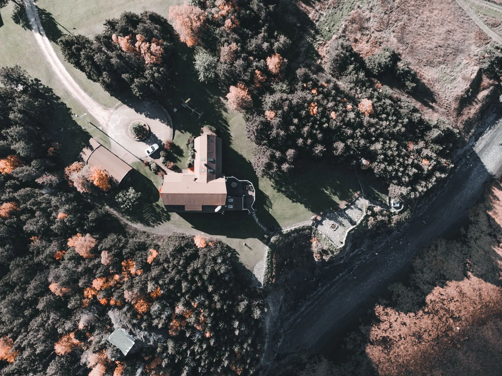 An aerial view of a property set among dense tree cover